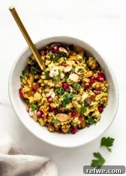 A bowl with Moroccan quinoa salad and a gold spoon