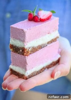 Vegan Strawberry Vanilla Cheesecake Bars, showcasing their vibrant pink layer and crumbly crust