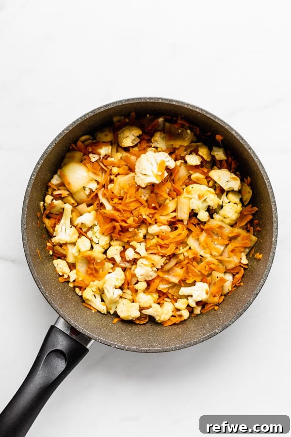 Your New Favorite Chickpea Burgers 5 Sautéed carrots and cauliflower simmering in a pan, ready to be transformed into delicious burgers.