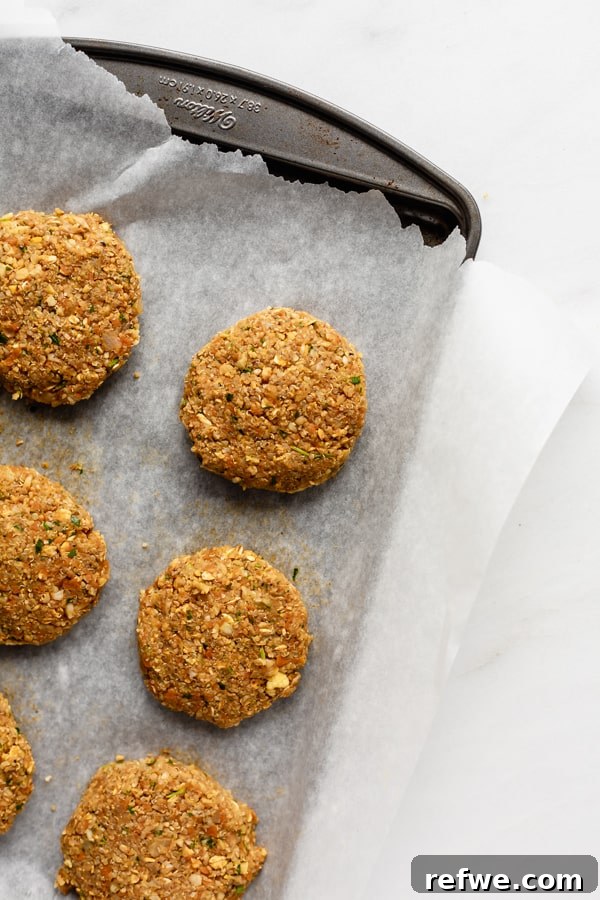 Your New Favorite Chickpea Burgers 8 Freshly shaped chickpea veggie burgers resting on a baking sheet, firming up before cooking.