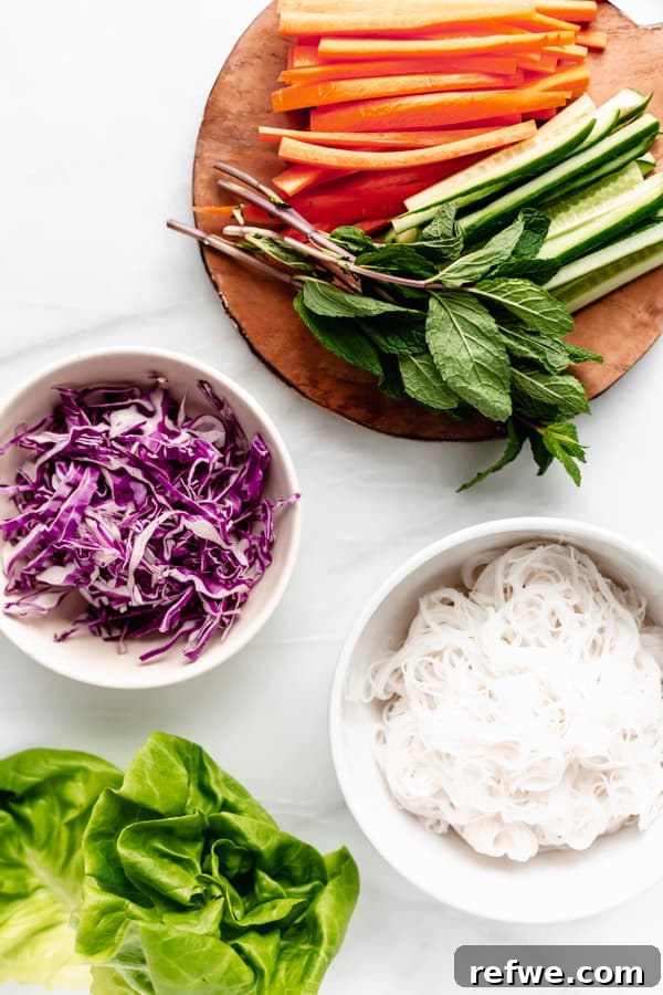 Summer Rolls 3 A flat lay photograph showcasing all the fresh and colorful ingredients laid out for making spring rolls, including rice paper, vegetables, noodles, and herbs.