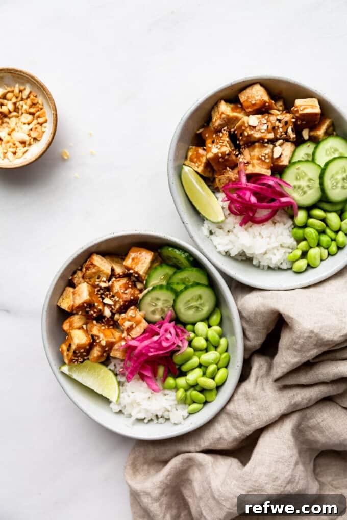 Peanut Tofu Power Bowls 8 Two freshly assembled peanut tofu bowls, garnished and ready to serve, accompanied by a clean napkin and a small bowl of crushed peanuts.