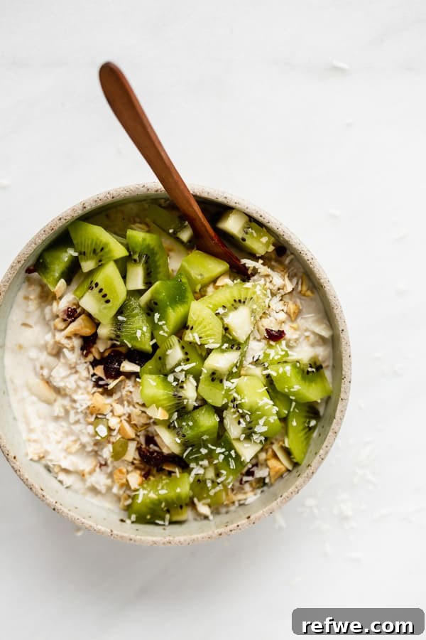 Tropical Coconut Cashew Bircher 6 A cozy bowl of Bircher muesli with a wooden spoon nestled in it, ready to be enjoyed. The texture and freshness of the muesli are clearly visible.