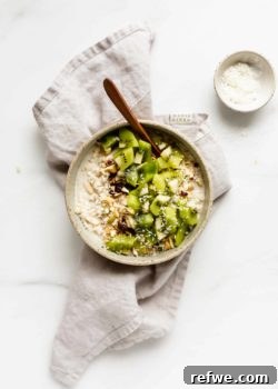 A bowl of creamy Coconut Cashew Bircher Muesli, served on a textured grey napkin, highlighting its rich and inviting appearance.