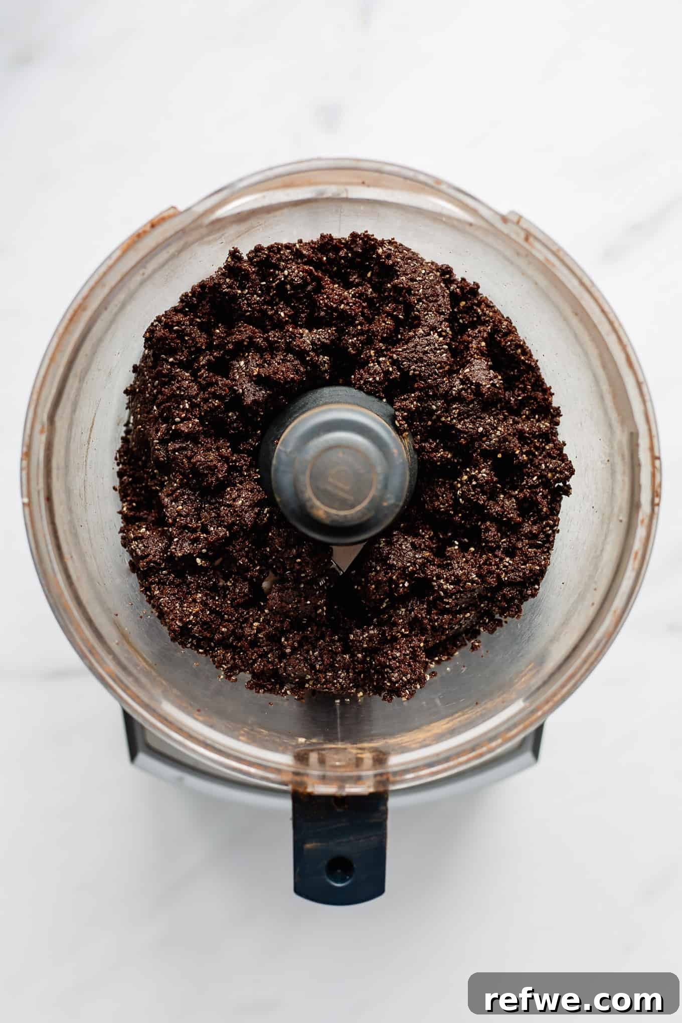 Fudgy Date & Chocolate Bites 5 The blended chocolate date ball mixture forming a sticky, uniform dough in the food processor.