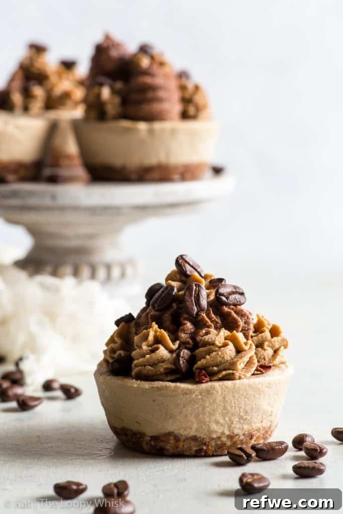Effortless Oven-Free Sweet Treats 13 A raw vegan coffee cupcake with coffee beans artfully arranged around it, on a dark surface.