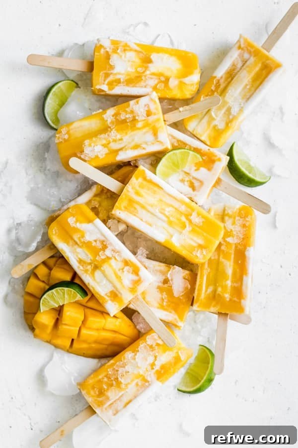 Effortless Oven-Free Sweet Treats 5 Several vegan mango lassi popsicles, vibrant yellow, stacked artfully on a light background.