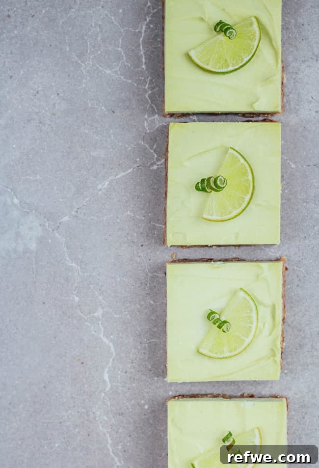 Effortless Oven-Free Sweet Treats 8 Four raw key lime pie bars with green filling on a grey board, garnished with lime zest.