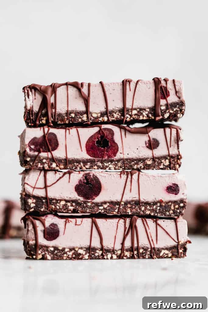 Effortless Oven-Free Sweet Treats 9 A stack of four vegan cherry cheesecake bars, showcasing a rich cherry topping over a creamy base.