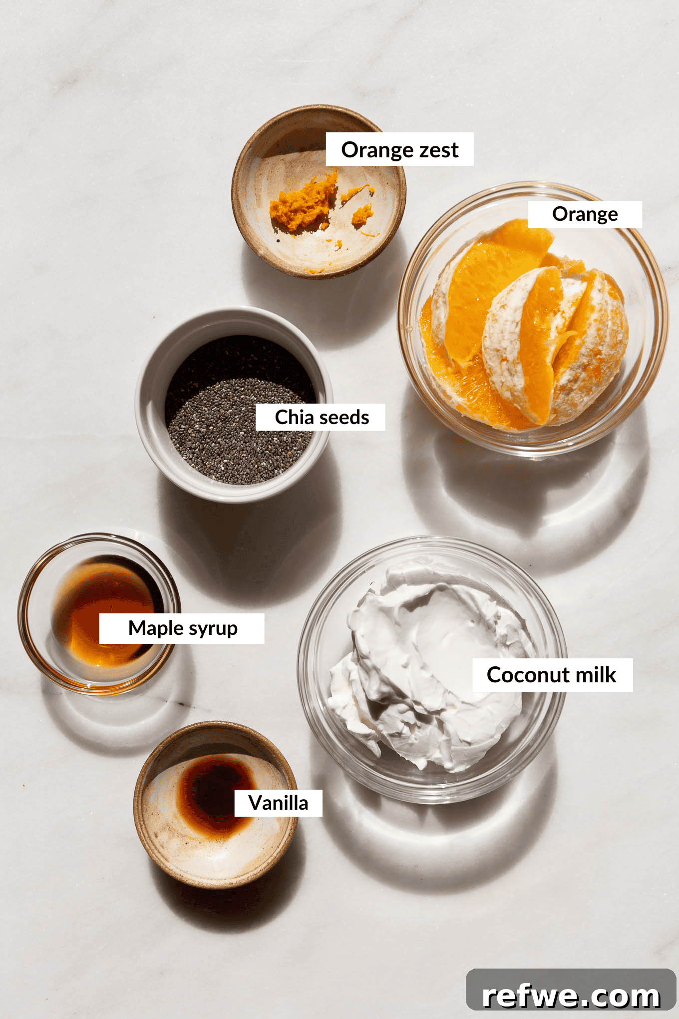Silky Orange Dream Chia Pudding 3 Ingredients laid out for orange chia pudding, including oranges, coconut milk, chia seeds, and maple syrup.