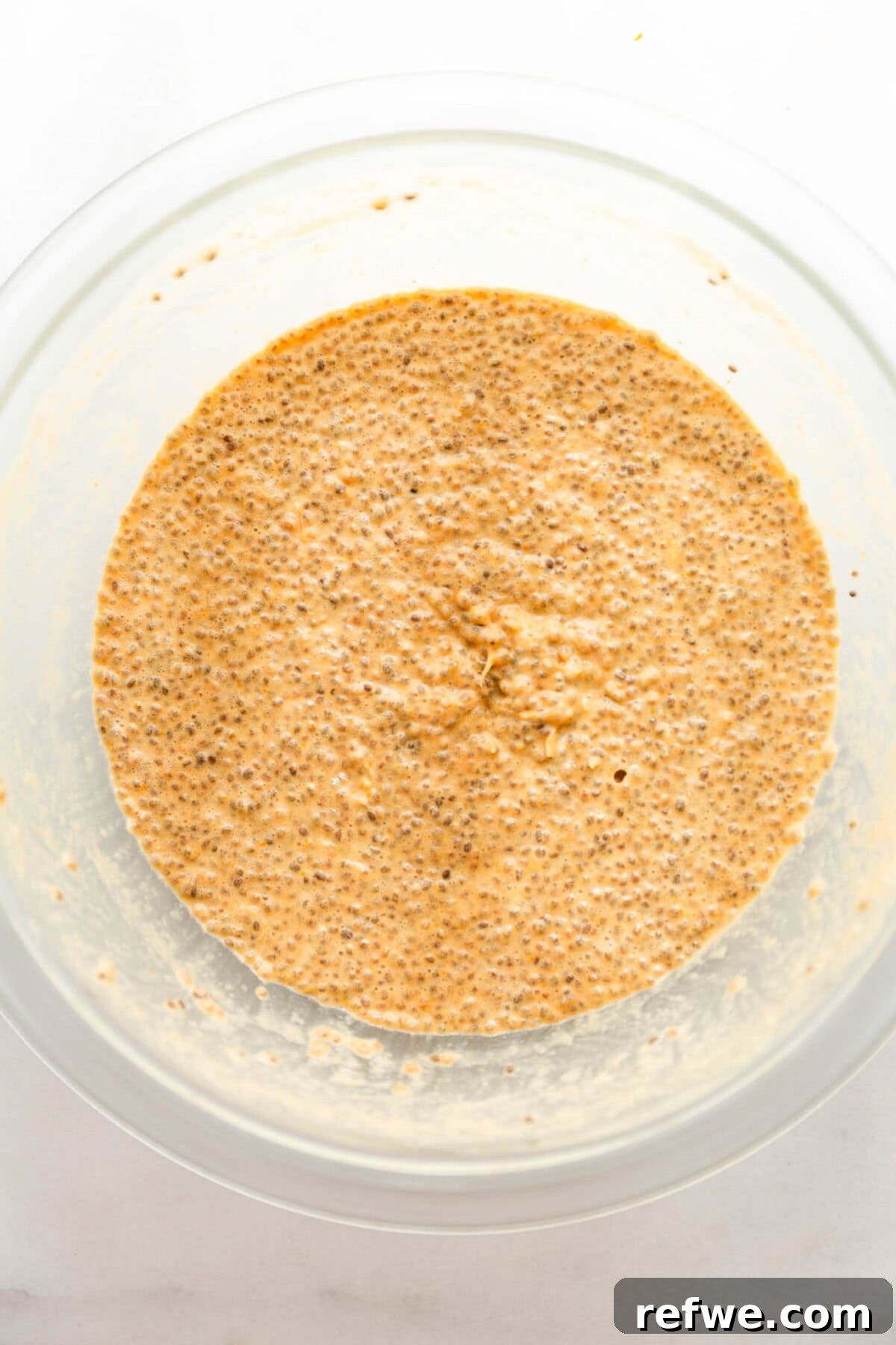 Silky Orange Dream Chia Pudding 8 The whisked orange chia seed pudding sits in a clear mixing bowl, ready for chilling.