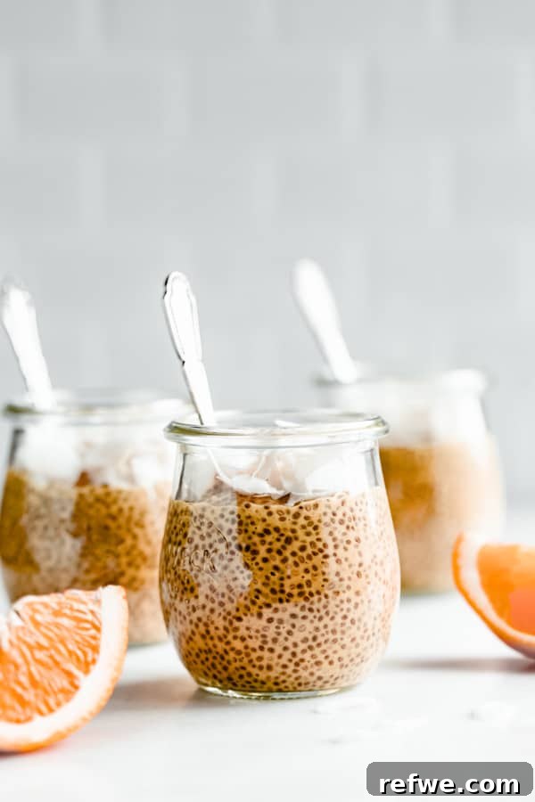 Silky Orange Dream Chia Pudding 9 A jar of finished orange creamsicle chia pudding, topped with orange slices, on a marble board.