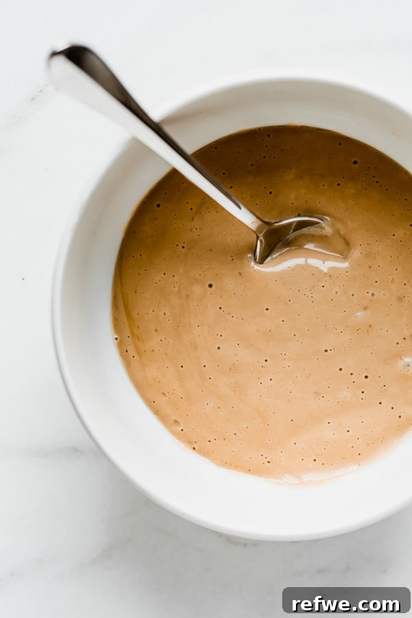 A white bowl brimming with smooth, creamy vegan vanilla pudding, perfectly set and ready for assembly into parfaits