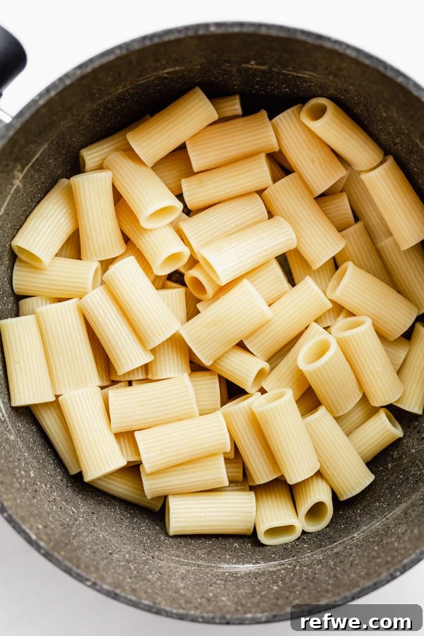 Bright Lemon Asparagus Pasta 4 Close-up shot of perfectly cooked rigatoni noodles in a large pot, showing their distinct shape and texture.