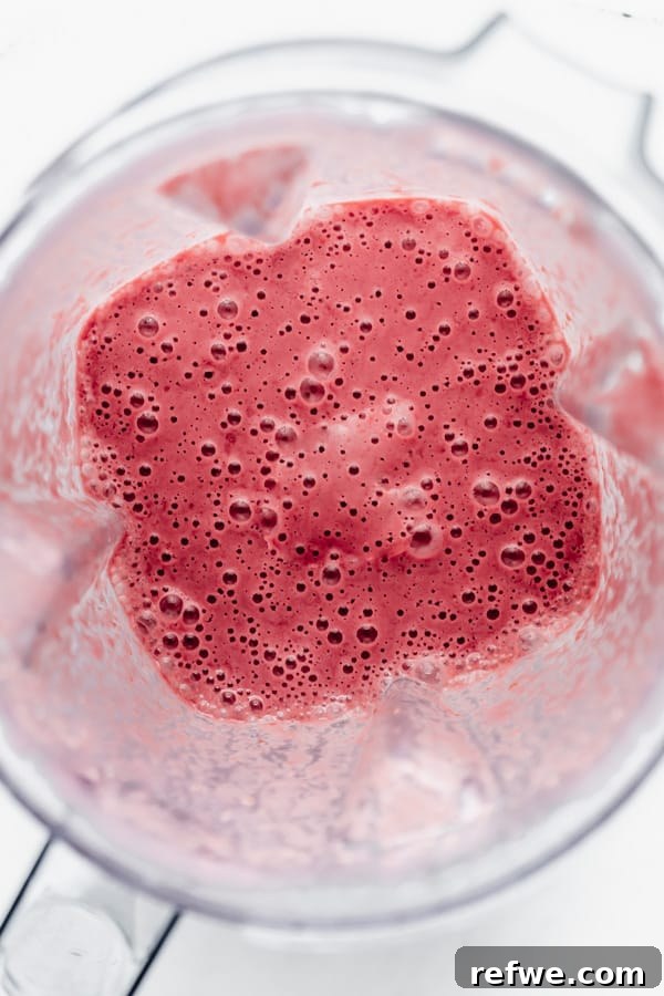 Decadent Chocolate Raspberry Chia Pudding 7 The smooth, vibrant pink mixture of blended raspberries and cashew milk inside a blender, ready for the next step of making raspberry chia pudding.