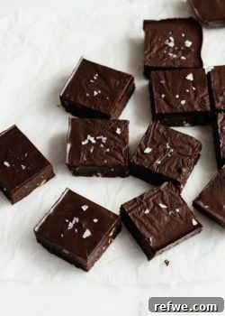 raw chocolate brownies cut up in squares on parchment paper