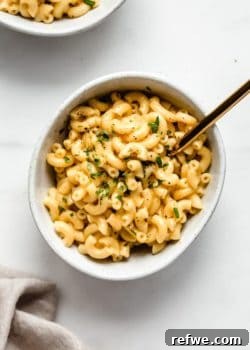 a bowl of mac and cheese with a gold fork in it