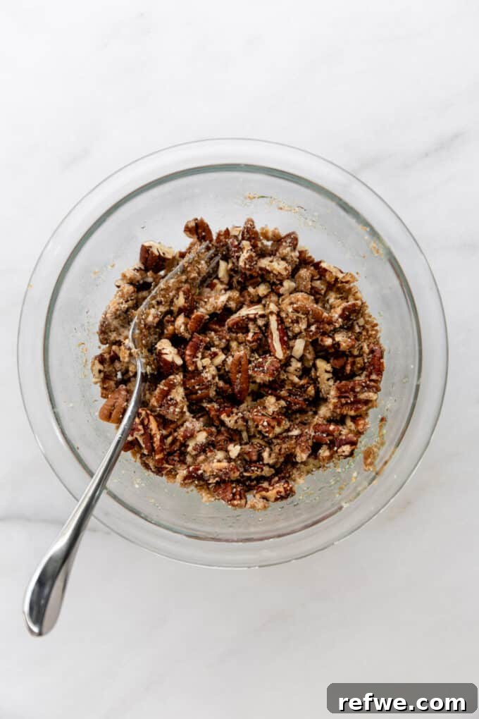 Pecan crumble topping, perfectly mixed, in a clear bowl, ready to be sprinkled.