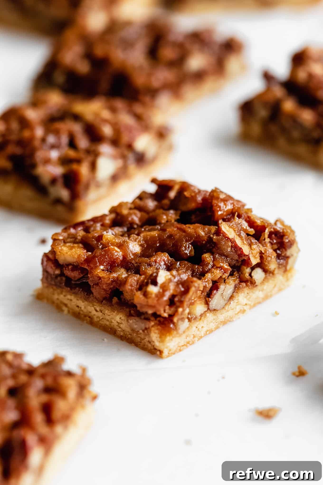 Beautifully cut Healthy Pecan Pie Bars arranged artfully on a marble board, showcasing their rich, golden-brown topping, crisp crust, and perfect individual portions.