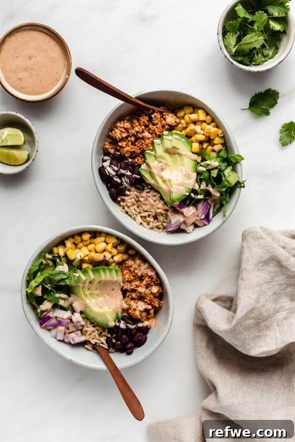Easy Chipotle Copycat Tofu Sofritas 6 Two vibrant burrito bowls featuring chipotle sofritas, accompanied by a side of creamy chipotle mayo and fresh lime wedges, highlighting a delicious meal presentation.