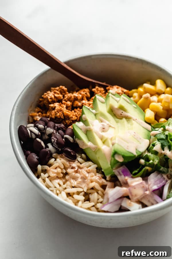 Easy Chipotle Copycat Tofu Sofritas 7 A close-up shot of a chipotle sofritas burrito bowl, garnished with a generous drizzle of creamy chipotle mayo, emphasizing the rich textures and vibrant colors for an appetizing display.