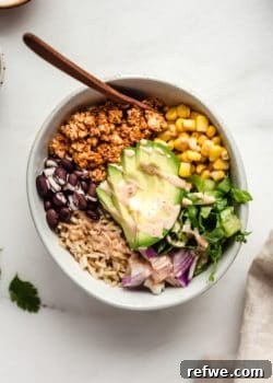 A bowl of chipotle sofritas with avocado, rice, beans, corn and lettuce, beautifully presented as a complete meal.