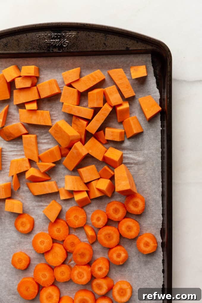 Warming Roasted Sweet Potato Carrot Ginger Soup 3 cut up sweet potato and carrots on a pan