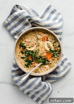 Creamy vegan wild rice soup in a bowl on a blue striped napkin.