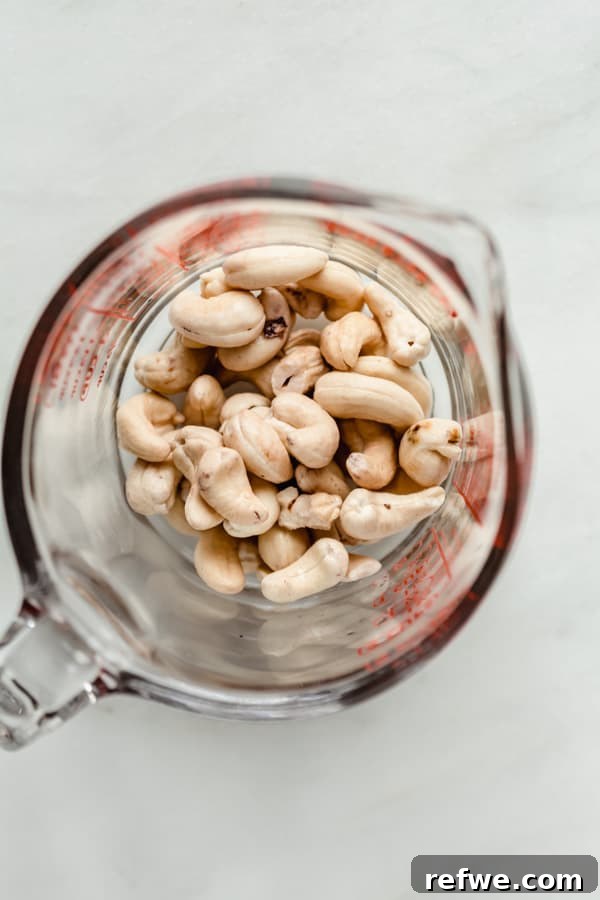 Creamy Instant Pot Wild Rice Comfort 5 A measuring cup filled with raw, unsalted cashews, ready for blending.