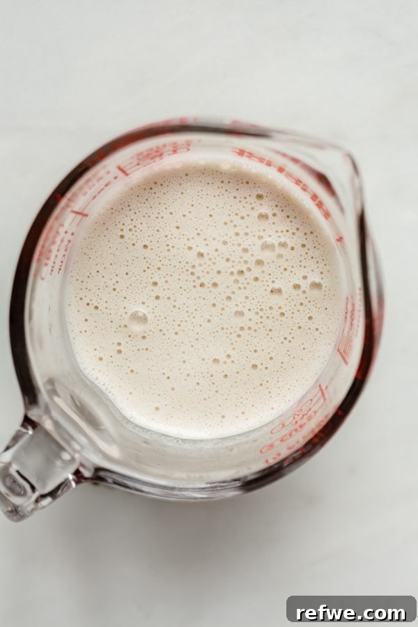 Creamy Instant Pot Wild Rice Comfort 6 A measuring cup containing freshly blended, smooth cashew cream.