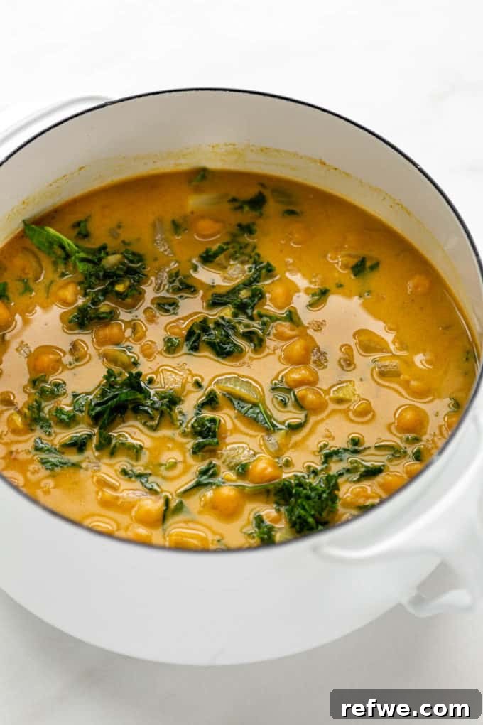 Creamy Coconut Chickpea Stew 9 A pot of finished coconut curry chickpeas with wilted kale mixed in.