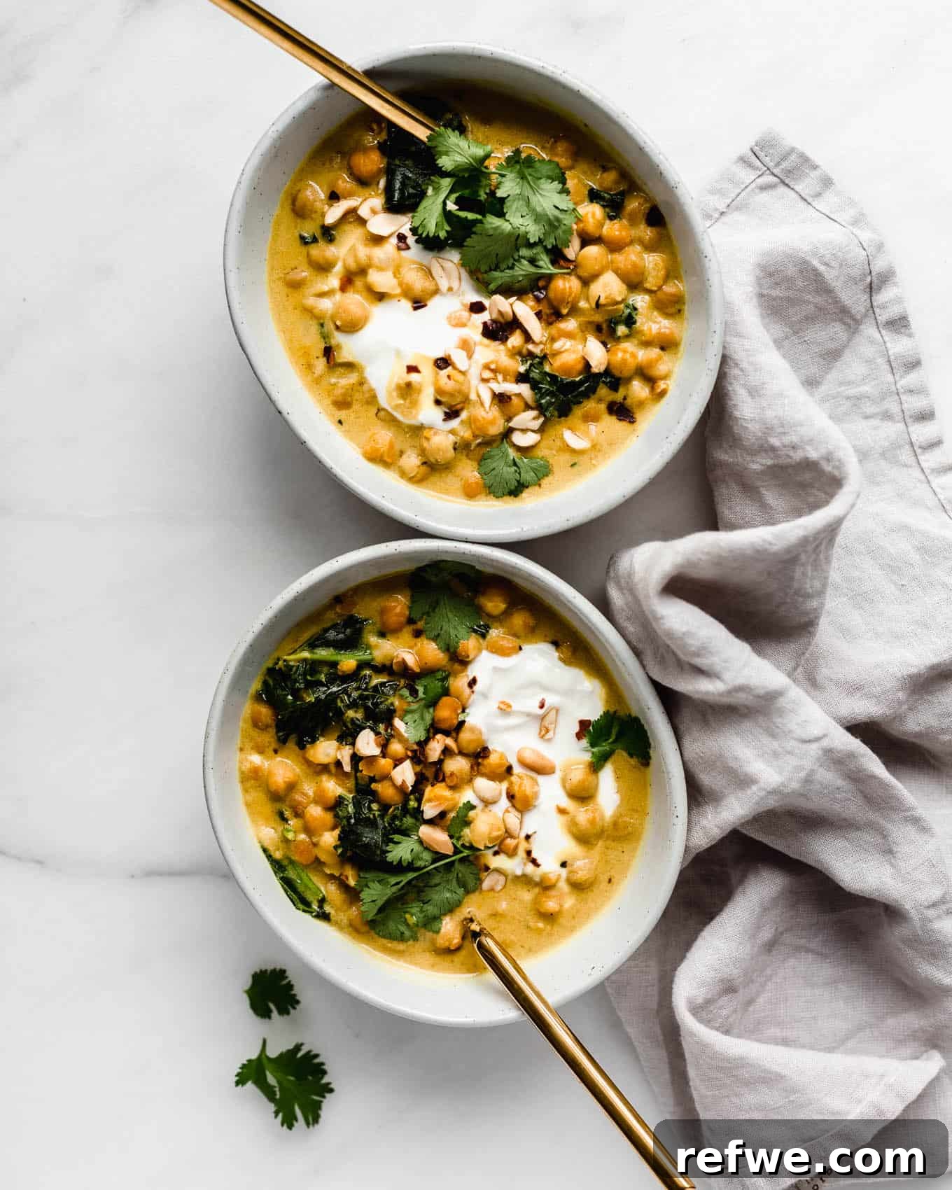 Creamy Coconut Chickpea Stew 10 Two beautifully plated bowls of coconut chickpea curry, one with fresh herbs and the other with a simple garnish, ready to be enjoyed.