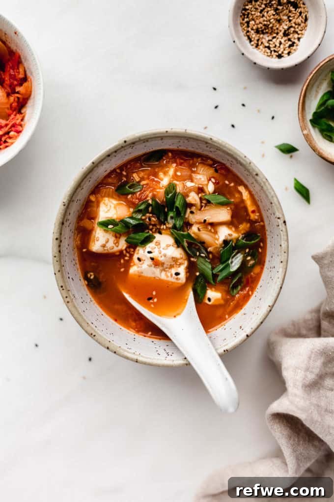Spicy Korean Soft Tofu Stew 9 A bowl of korean tofu soup with a spoon in it