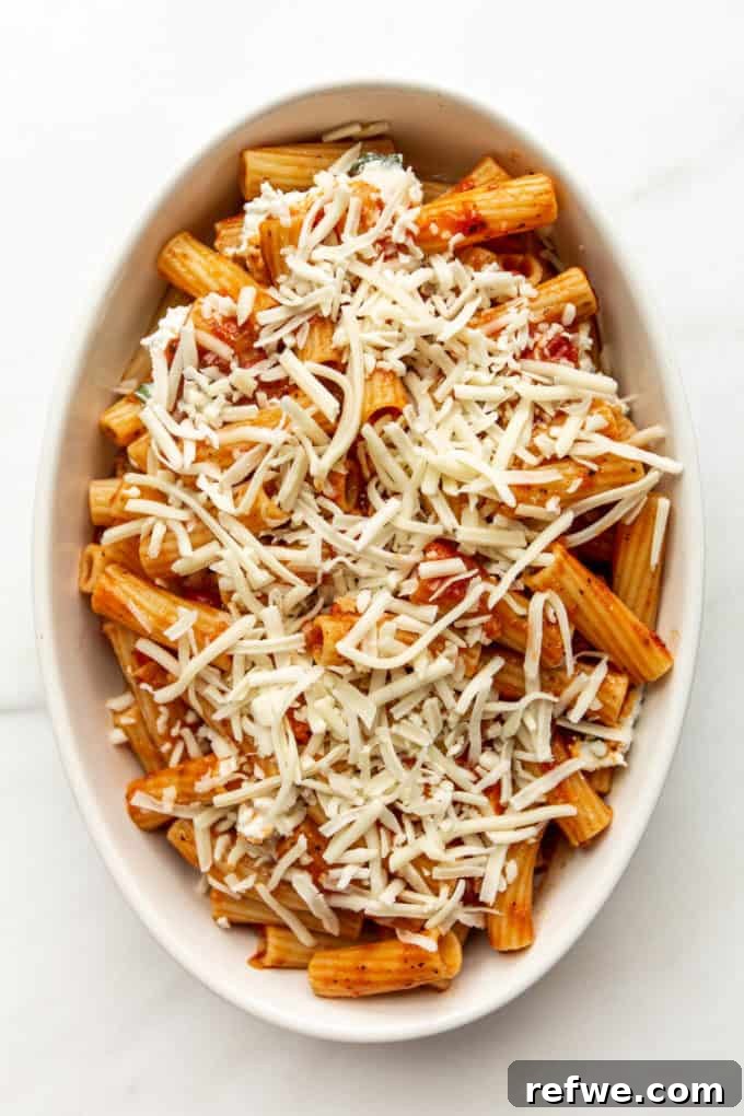 Rich Ricotta Vegetarian Ziti Bake 12 ziti noodles in sauce topped with shredded cheese in a baking dish