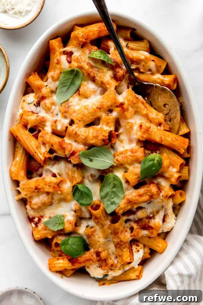 Rich Ricotta Vegetarian Ziti Bake 14 baked ziti in an oval baking dish with a serving spoon in it