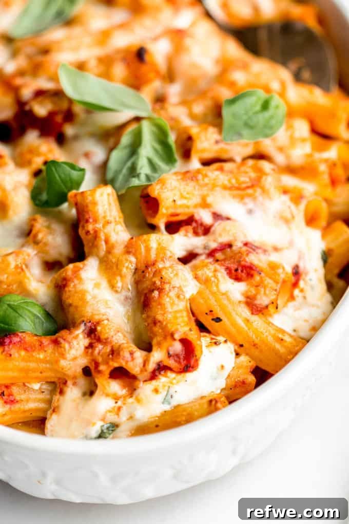 Rich Ricotta Vegetarian Ziti Bake 15 A close up of baked ziti topped with cheese and basil leaves