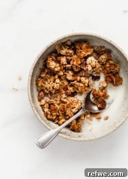 A bowl with banana bread granola and a spoon in it