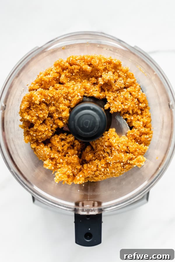 Sun Kissed Apricot Coconut Power Bites 4 The processed apricot energy ball mixture in a food processor, forming a sticky, uniform dough.