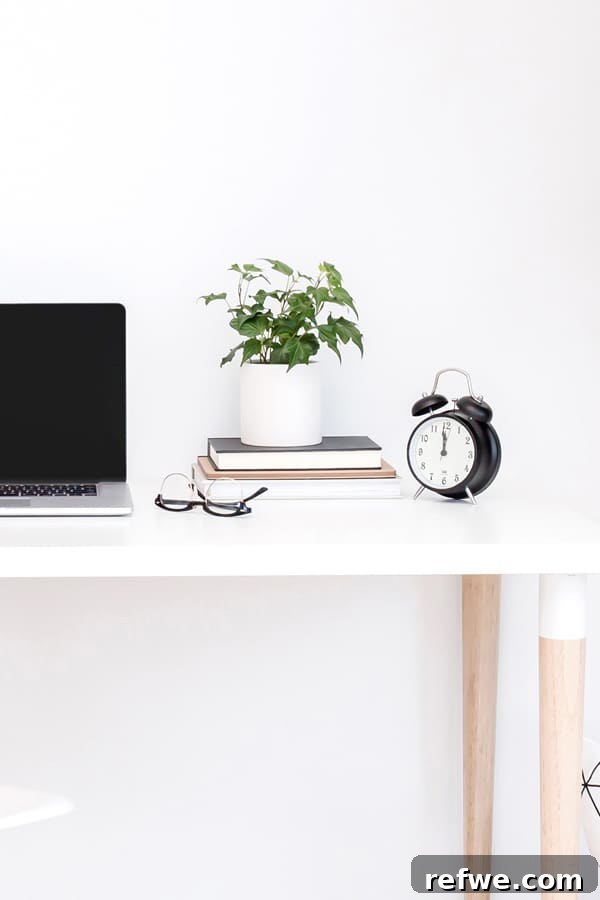 Supercharge Your Day: The 25-Minute Method for Hours of Work 2 A clock, stack of books and plant on a white desk