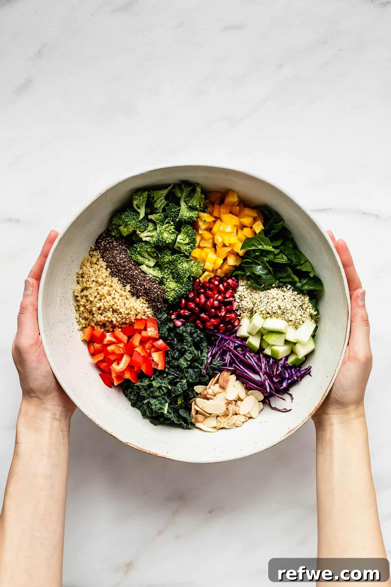 Vibrant Vitality Bowl 2 Two hands gently holding a vibrant bowl of Superfood Salad, showcasing a colorful mix of kale, quinoa, and fresh vegetables.