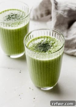 Two glasses of vibrant matcha green tea smoothie, garnished and ready to drink.