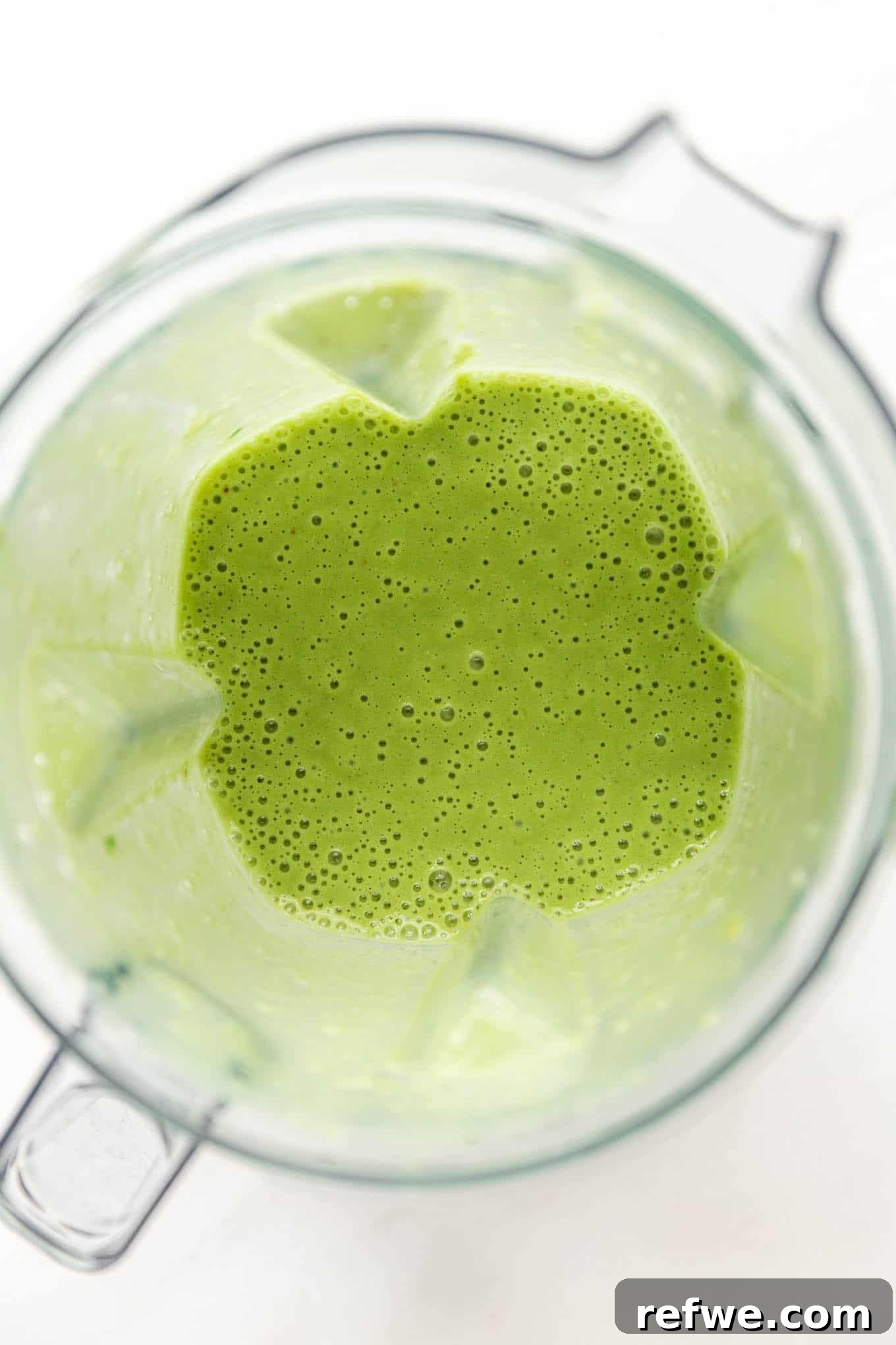 Vibrant Matcha Smoothie 5 The matcha smoothie actively blending in a high-speed blender, creating a smooth, green vortex.