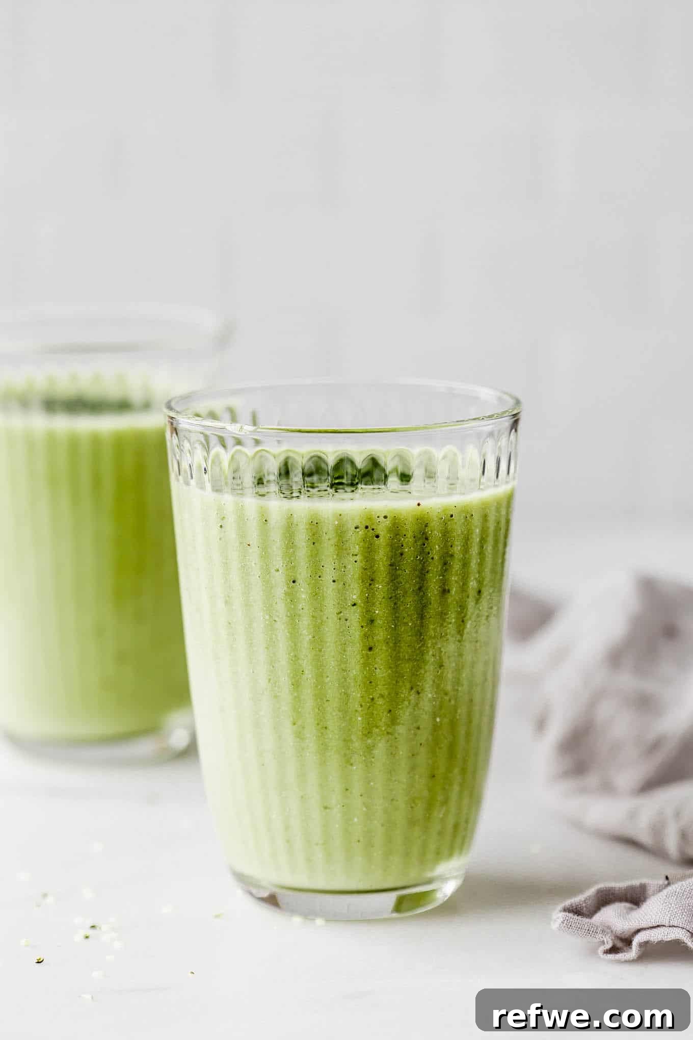 Vibrant Matcha Smoothie 6 Two beautifully prepared matcha smoothies in glasses, resting on a marble counter, ready to be served.
