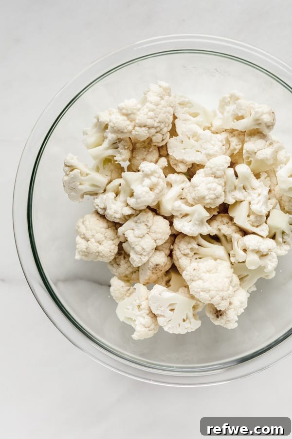Buffalo Cauliflower Bites 3 Cauliflower florets in a clear mixing bowl, ready for battering.