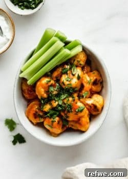 buffalo cauliflower wings in a bowl with celery on the side