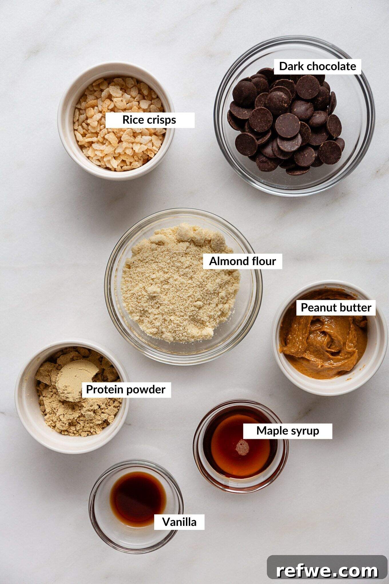 Decadent Chocolate Peanut Butter Muscle Bars 3 Ingredients laid out on a table to make peanut butter protein bars, including almond flour, protein powder, and peanut butter.
