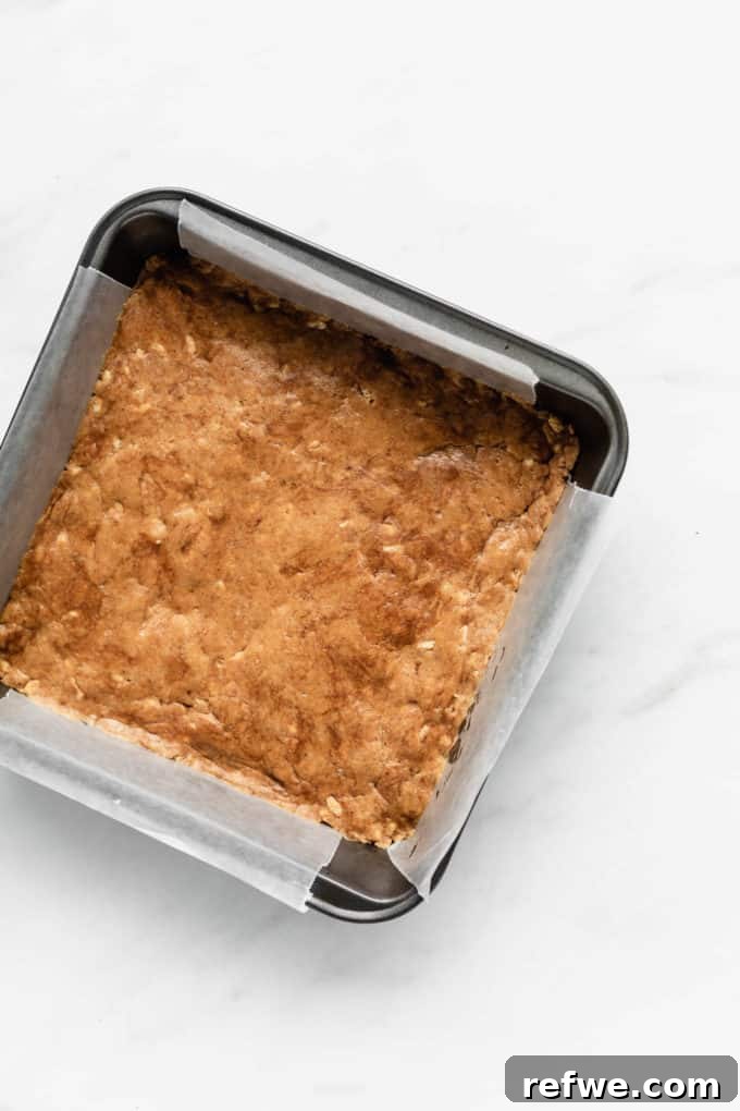 Decadent Chocolate Peanut Butter Muscle Bars 7 The protein bar dough pressed evenly into an 8x8 inch pan lined with parchment paper.