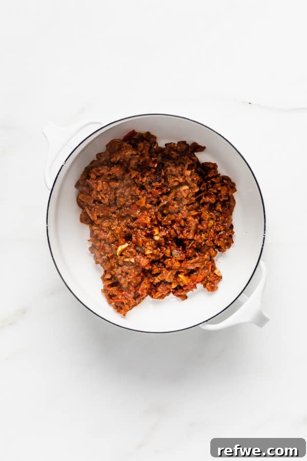 Zesty Plant-Based Taco Pasta 3 A white pot containing perfectly browned vegan taco meat, seasoned with aromatic spices.