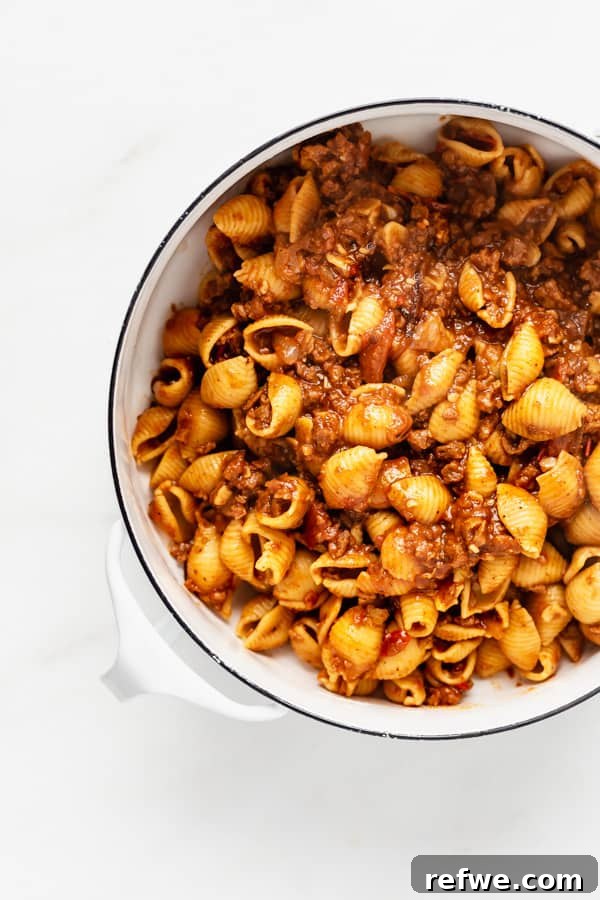 Zesty Plant-Based Taco Pasta 5 A top-down view of perfectly cooked shell noodles coated in a rich vegan taco pasta sauce, resting in a pristine white pot.