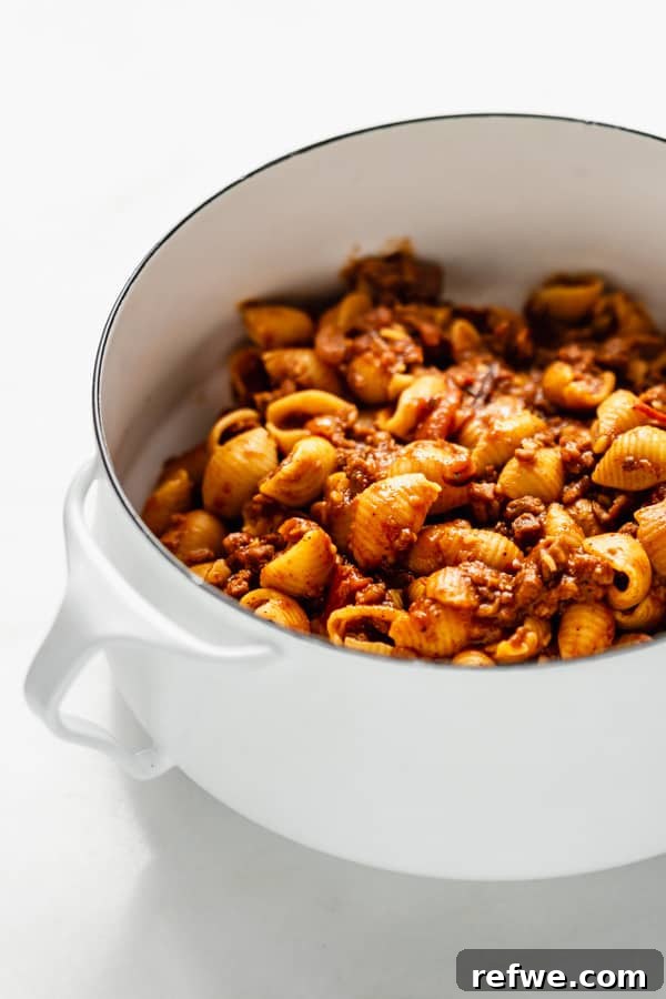 Zesty Plant-Based Taco Pasta 6 A generous serving of vegan taco pasta, showcasing the vibrant sauce and noodles, presented in a rustic white pot.